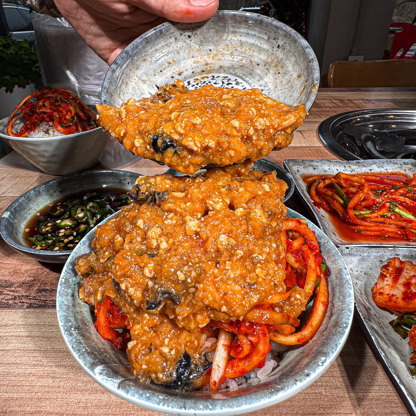 그릇에서 흘러내리는 양념과 겉절이를 밥 위에 얹은 장면